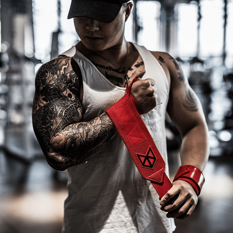 Athlète préparant ses Bandes de Poignet Musculation Rouges pour une session d'haltérophilie.
