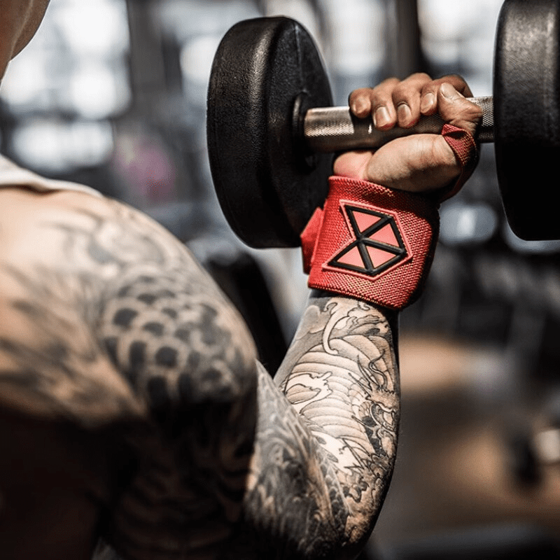 Bandes de Poignet Musculation Rouges posées sur un banc de musculation, prêtes à l'emploi.