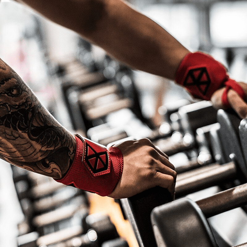 Personne attachant les Bandes de Poignet Musculation Rouges, illustrant leur utilisation facile.