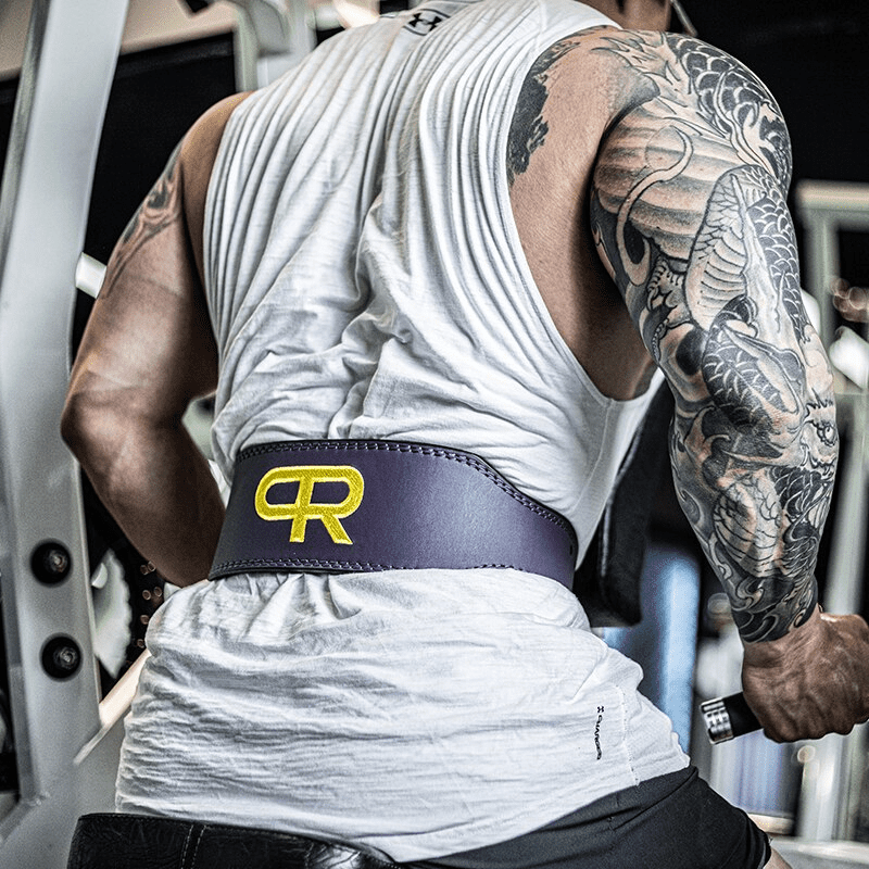 "La Ceinture de Musculation 'PR' Mauve posée à côté de poids, prête pour l'entraînement"