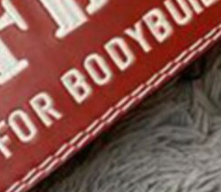 "La Ceinture de Musculation IFBB Rouge en gros plan, soulignant sa conception réglable et sa doublure en mousse pour le confort."