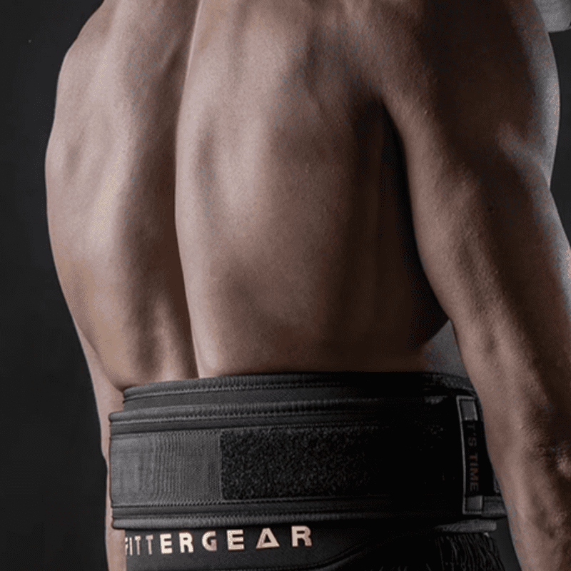 Image d'une Ceinture de Musculation Polyester Noire posée sur un sol de gymnase, prête pour l'entraînement.