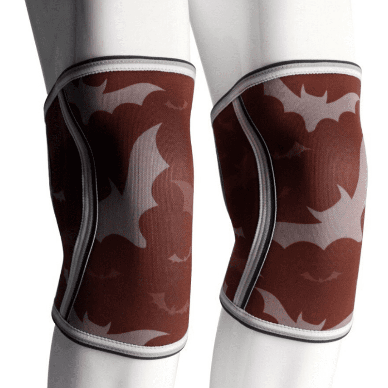 Genouillère Haltérophilie Bat Red offrant un soutien supérieur pour des performances optimales en haltérophilie avec un design de chauve-souris audacieux.