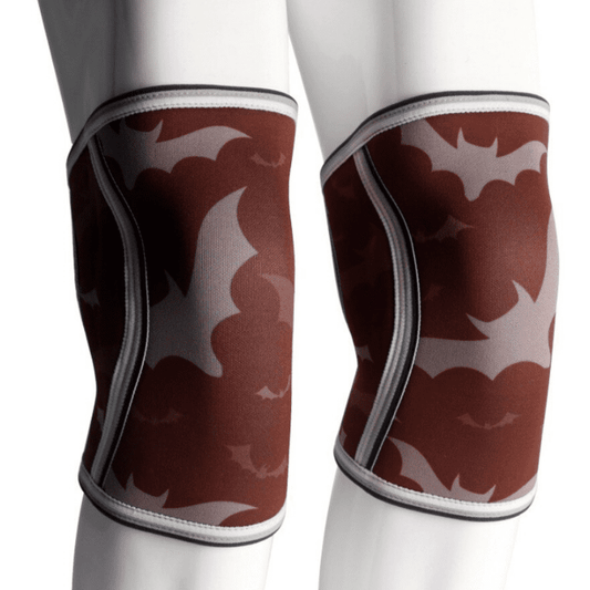 Genouillère Haltérophilie Bat Red offrant un soutien supérieur pour des performances optimales en haltérophilie avec un design de chauve-souris audacieux.